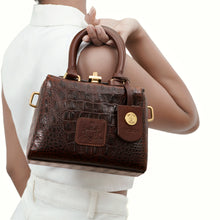 Load image into Gallery viewer, A Woman holding a Hidesign Ritz 01 brown croc-embossed sling bag with top handles and gold hardware.