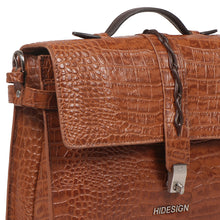 Load image into Gallery viewer, Close-up of Hidesign tan crocodile-textured leather bag showing top handle, flap, and twist-lock.