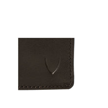 Load image into Gallery viewer, A macro shot of a brown leather wallet's corner, showing the Hidesign embossed logo and stitching.