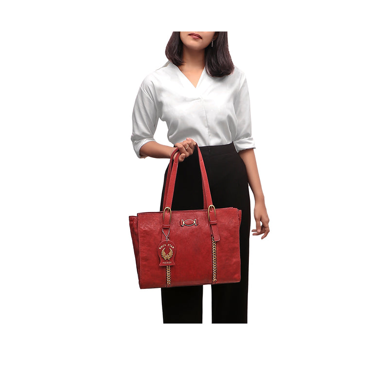 Woman holding a marsala red leather tote bag with gold chain details & “Rock Star” tag by Hidesign.